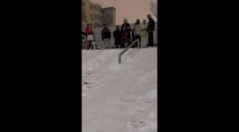 Student snowboards down handrail during winter weather