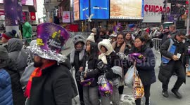 New Year’s Revelers arrive in Times Square, clearing security checks and receiving party hats