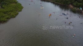 Tourists swim in the waters of the Guarau River in Peruibe in Brazil