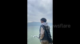 Man Bluffs to Feed Bread to Seagulls Only to Eat It Himself in Kunming, China