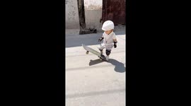 Adorable toddler, 2, rides skateboard across street
