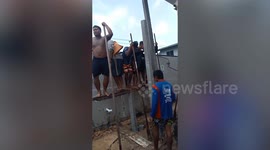 Workers stand on plank to bury it with their weight in construction hack