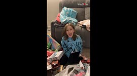 Little girl unwraps delight surprise by surprise