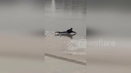 Policeman crawls 100ft over frozen lake to save woman stuck on ice