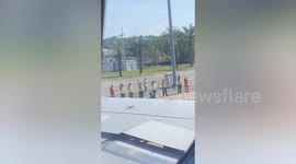 Airport ground workers wave goodbye to leaving plane