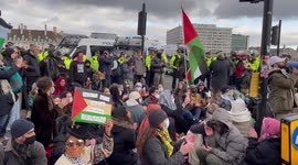 Pro-Palestine protesters sit down near Westminster Bridge in London, UK