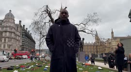 Idris Elba stands in Parliament Square with clothing respresenting victims of knife crime in the UK