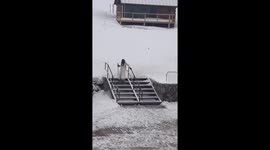 Woman Descends Stairs in Skis