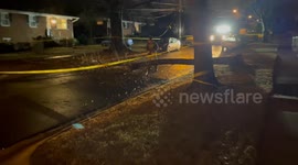 Man uses chainsaw to cut fallen tree blocking street after storms and high winds