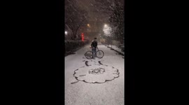Winter blossoms: Creative flower crafted in snow by man with bike
