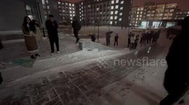 Students form human train and slide down icy slope in China