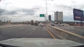 Trashbag flies off dump truck and slams on car's windscreen