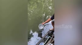 Policeman saves tilapia fish stuck in net at polluted Thai canal