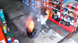 Quick-thinking shop owner bravely pushes flaming tyre away after it falls from truck in China