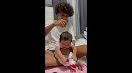 Baby laughs uncontrollably while having his head tickled with massager