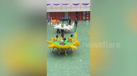 Teachers hold amusing relay race wearing group inflatable rings