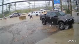 Scooter accidentally slips into uncovered manhole during floods in Thailand