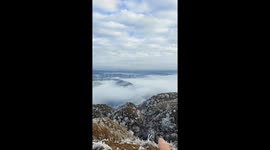 Woman stands in boundary of two Chinese provinces with visible weather differences