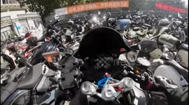 Motorcycles fall like dominoes when well-meaning motorist tries to fix scooter's position