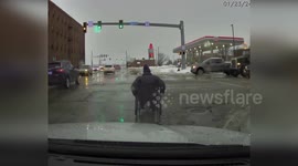 Police Officer Assisting Man in Wheelchair Across Busy Intersection in South Bend, USA