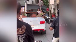 Bentley-driving show-off cruises through city with a baby lion leaning from car