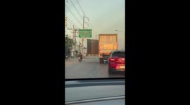 Truck drives along highway with container door swinging open