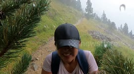 Couple of hikers are suprised by a storm pouring hail in Pyrenees