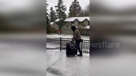 Father has amusing struggle down frozen path in Oregon