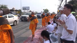 Hundreds of Buddhist monks walk on roadside bed of flower petals in Thailand
