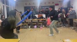 Blindfolded boy playfights with classmates using foam rods