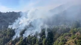 Philippine Air Force helicopters dump water on forest fire