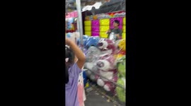 Girl flexes her darts skills by popping balloons on coconut shy