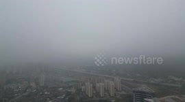 Drone flies through thick storm clouds and reveals bright sunny day above