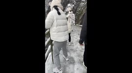 Hikers slide down frozen path to descend mountain in China