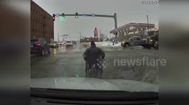 Police officer helps wheelchair user across intersection