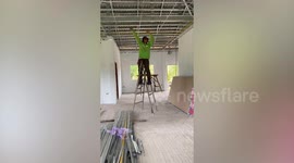 Worker's incredible hack sees him use ladder as stilts when installing wires