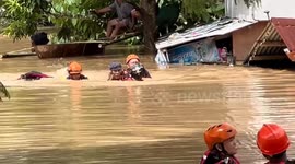 Firefighters wade through floods to rescue trapped residents in the Philippines