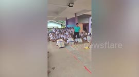 Schoolkids race in cardboard caterpillar game