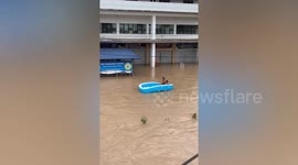 Locals use inflatable pool as makeshift boat to get through flood