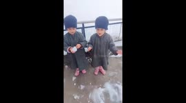 Excited identical twin sisters react to snow in Kashmir