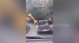 Excavator tumbles down cliff with driver still inside
