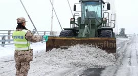 Armed police clear snow and icy to free stranded motorists on Chinese highway