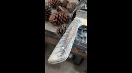 Oiling up a knife handle with a pinecone inside. This knife is almost ready!