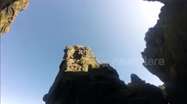 Climber falls off high sea stack, harness stops him inches from the ground