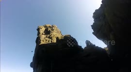 Climber falls off high sea stack, harness stops him inches from the ground
