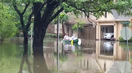 People canoe through flooded residential area during Houston floods