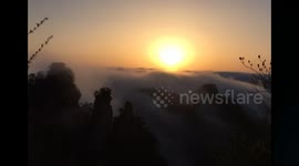 Snapshot footage of cloud waterfall in mountain range after raining