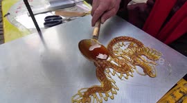 A Folk Artist is Making A Sugar Painting