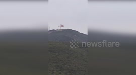 Firefighters and Helicopter Battle Mediterranean Bushfire Threatening Wind Turbines in Italy