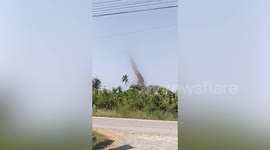 Huge dust devil tornado whips through field in Thailand